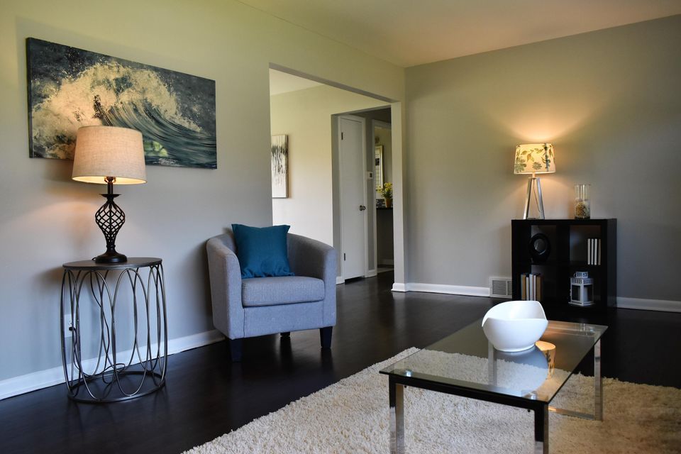 A living room with a chair a table and a lamp