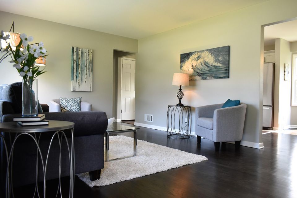 A living room filled with furniture and a painting on the wall