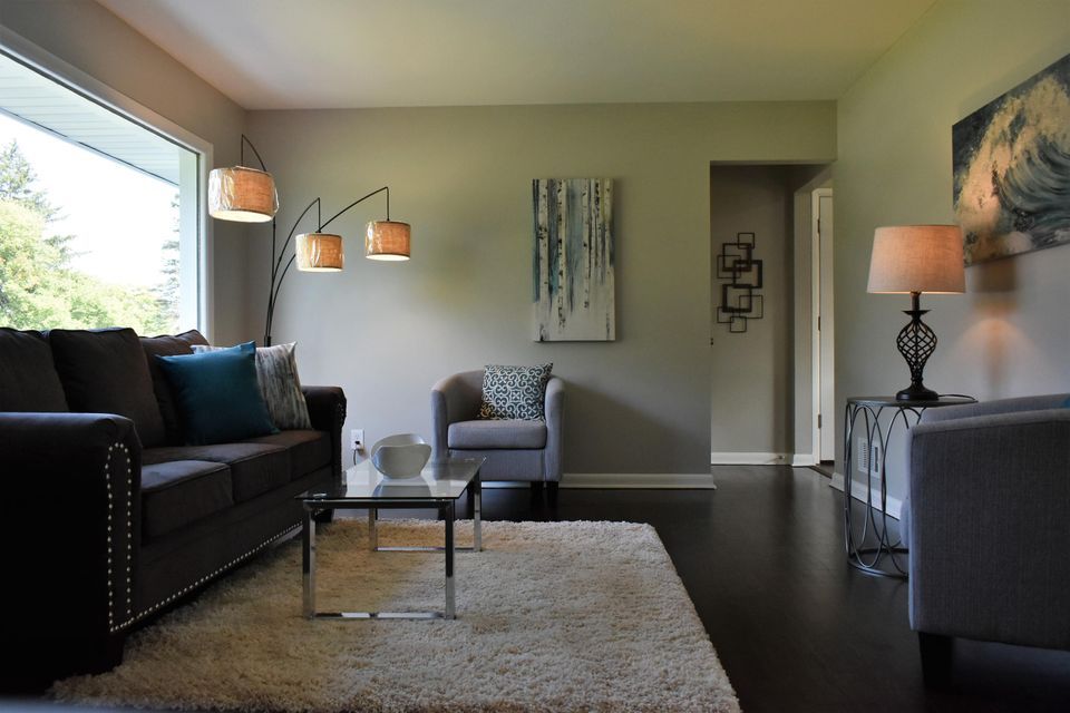 A living room with a couch and two chairs