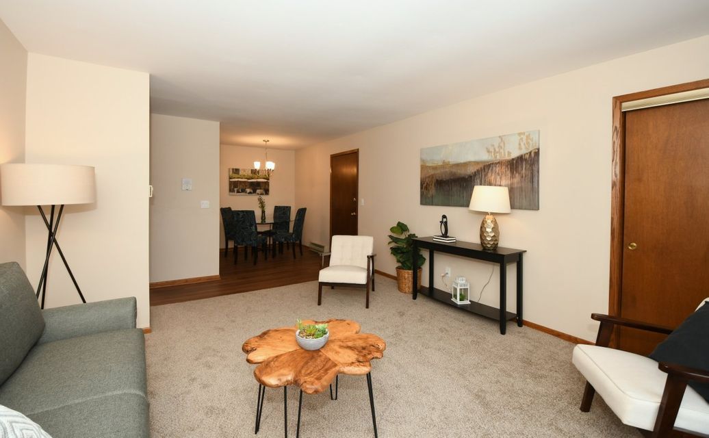 A living room with a couch and chairs and a wooden table