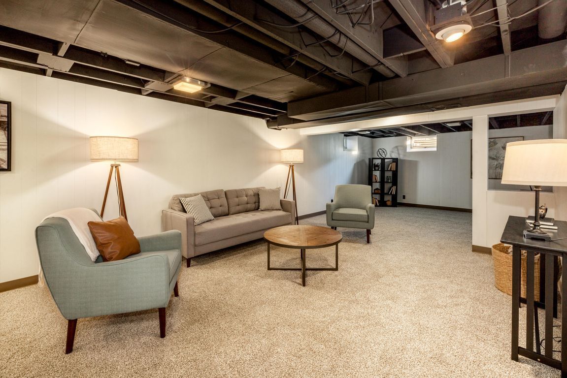 A living room with a couch, chairs, and a coffee table.