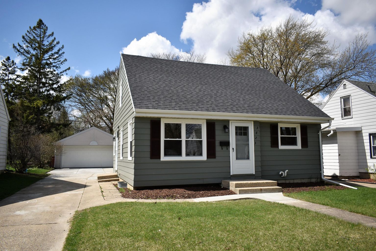 A small house with a black roof and white trim