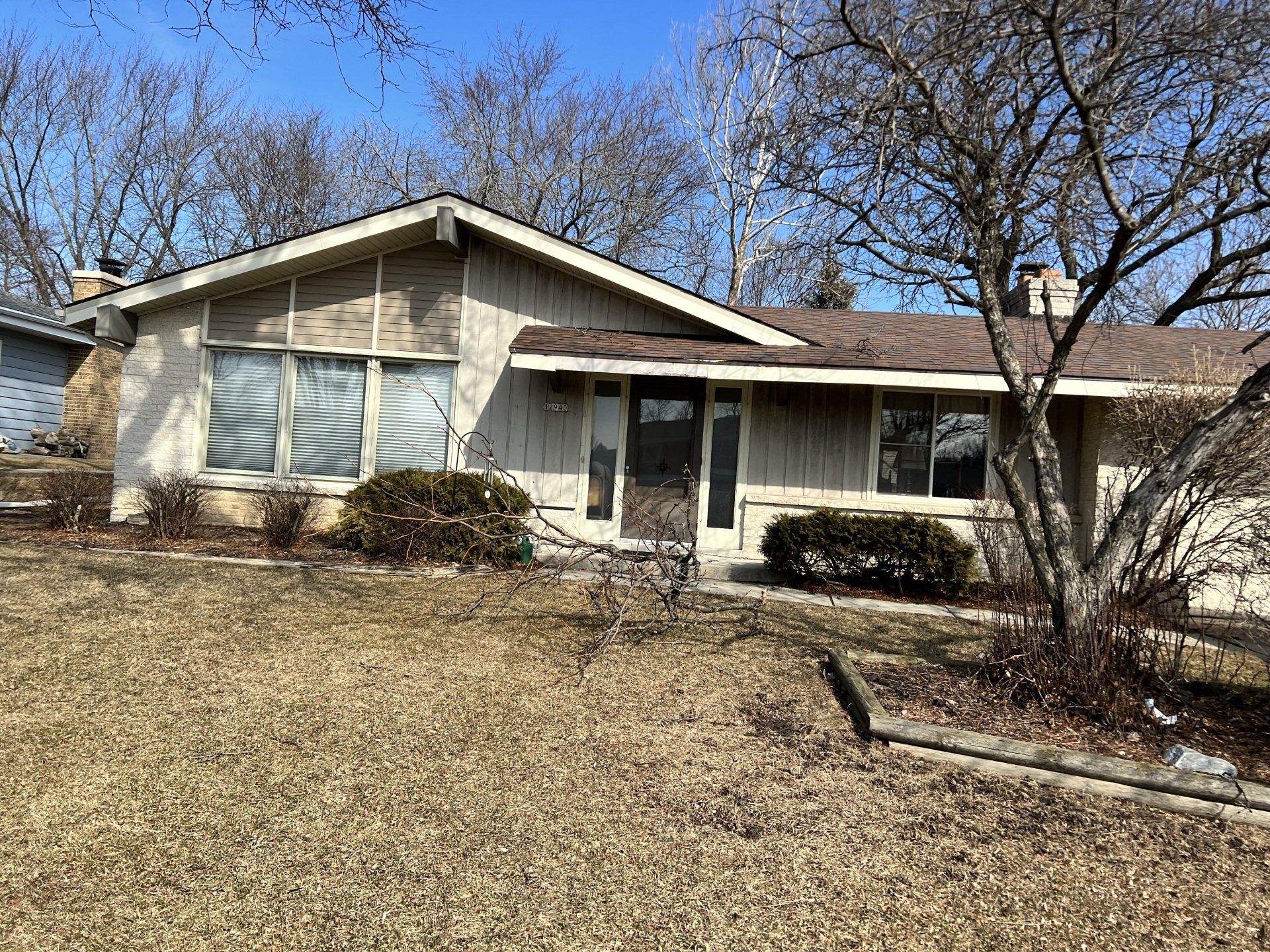 A house with a lot of windows and a lot of leaves on the ground.