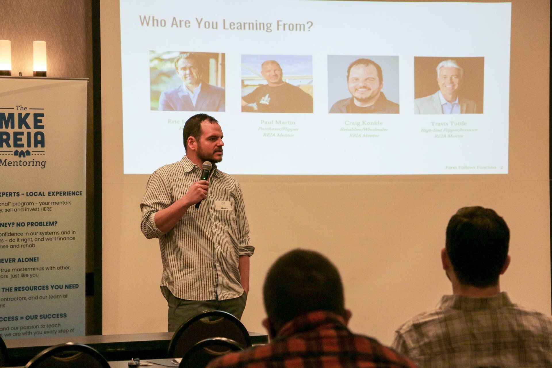 A man giving a presentation in front of a screen that says 