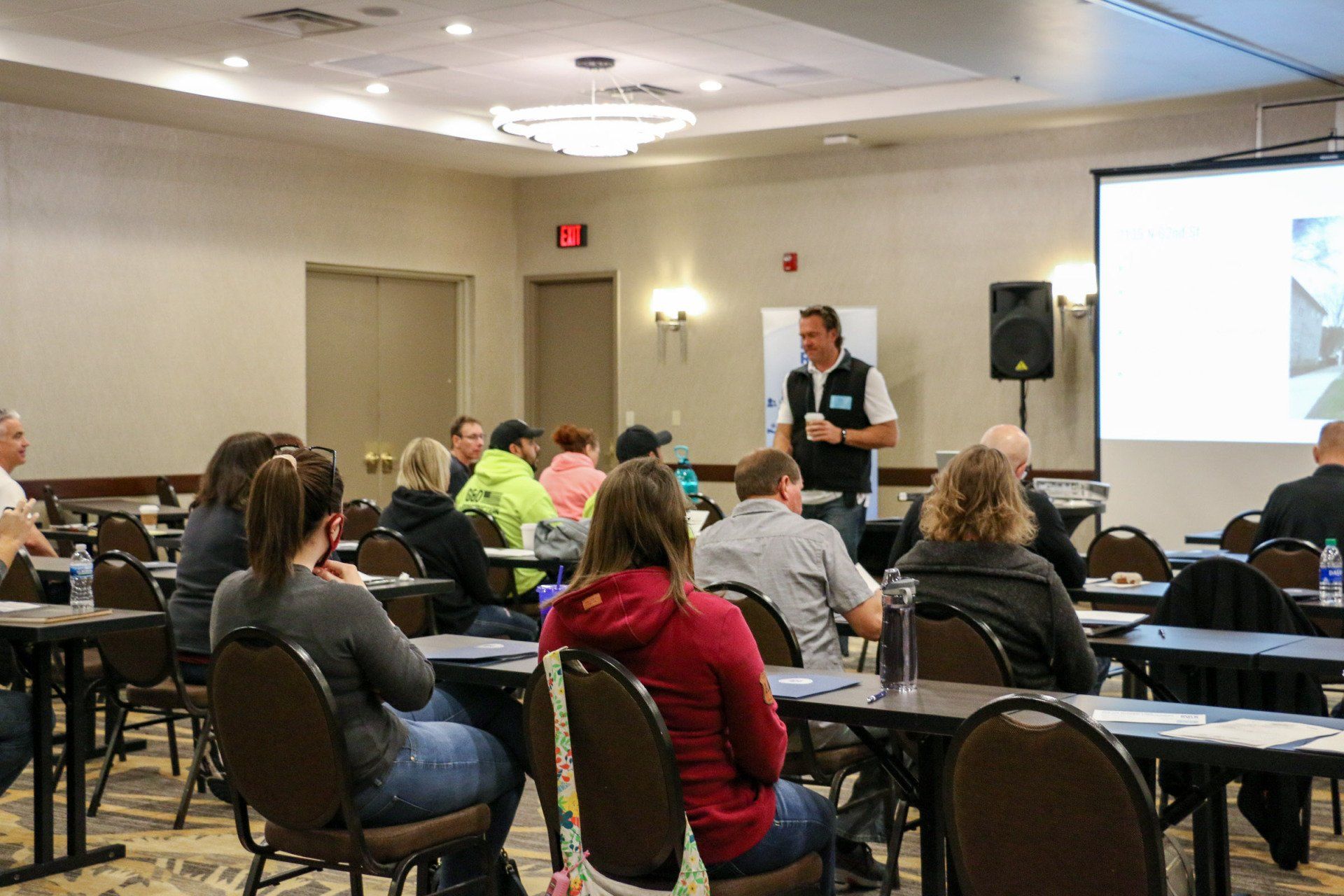 A man is giving a presentation to a group of people in a conference room.
