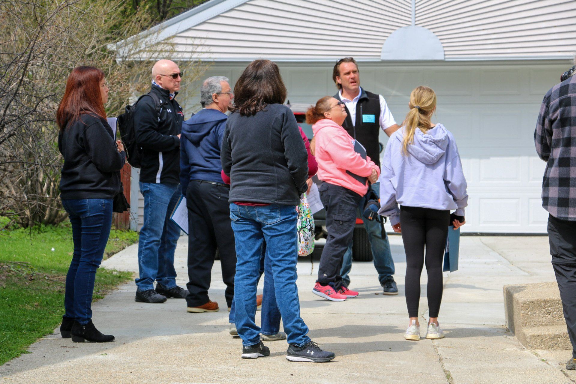 A group of people are standing outside of a house.