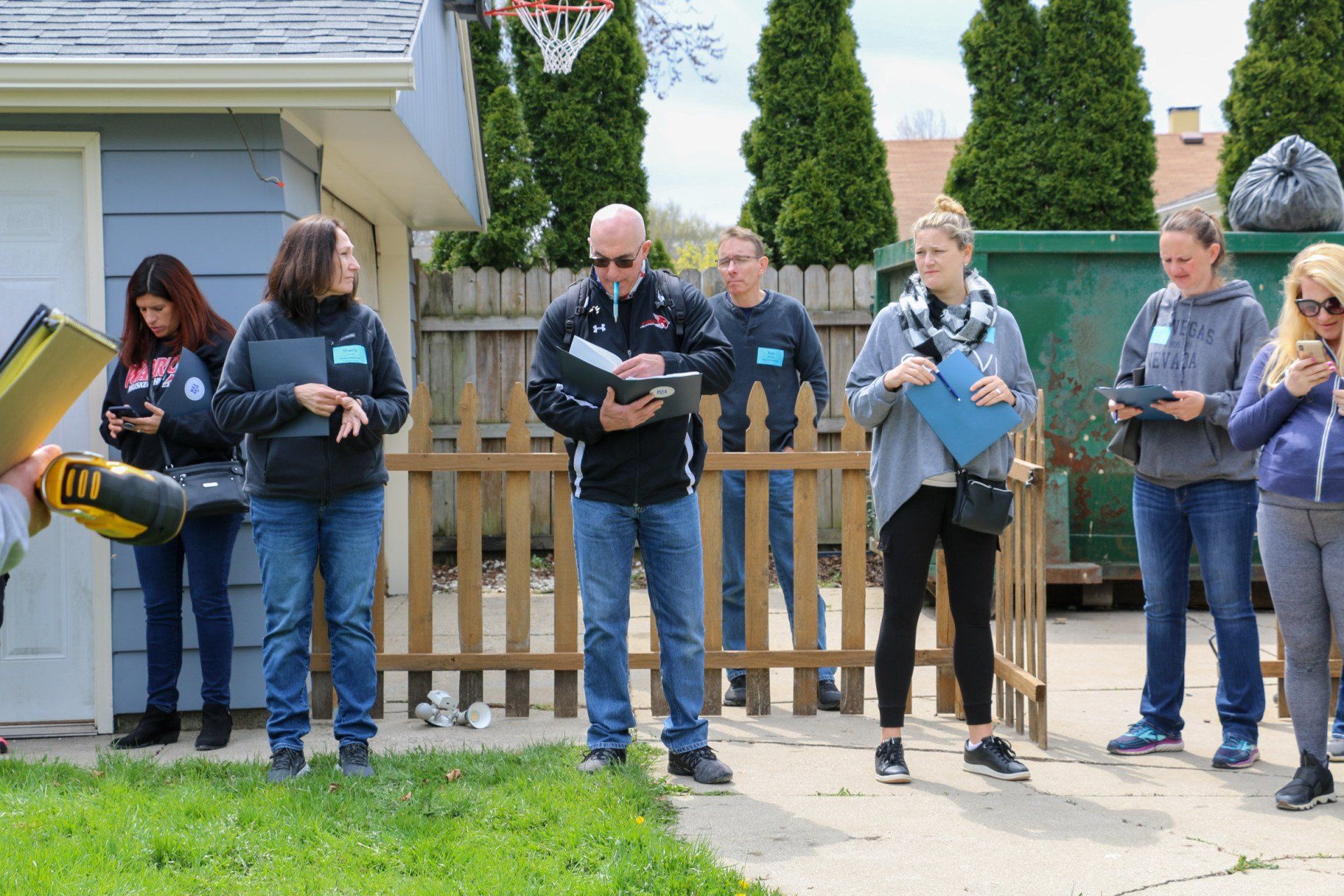 A group of people are standing in front of a house.