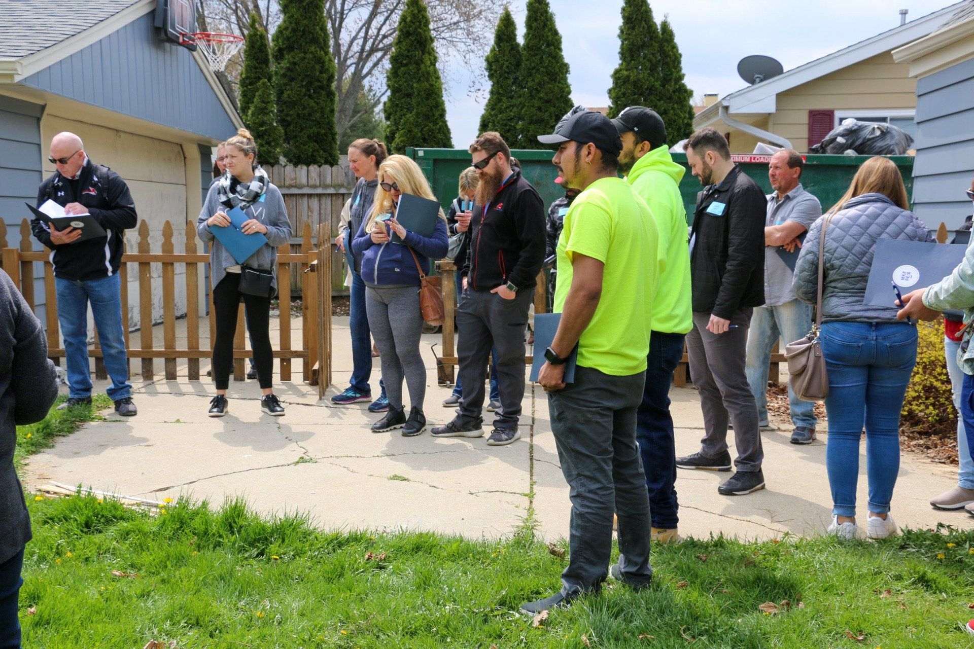 A group of people are standing in front of a house.