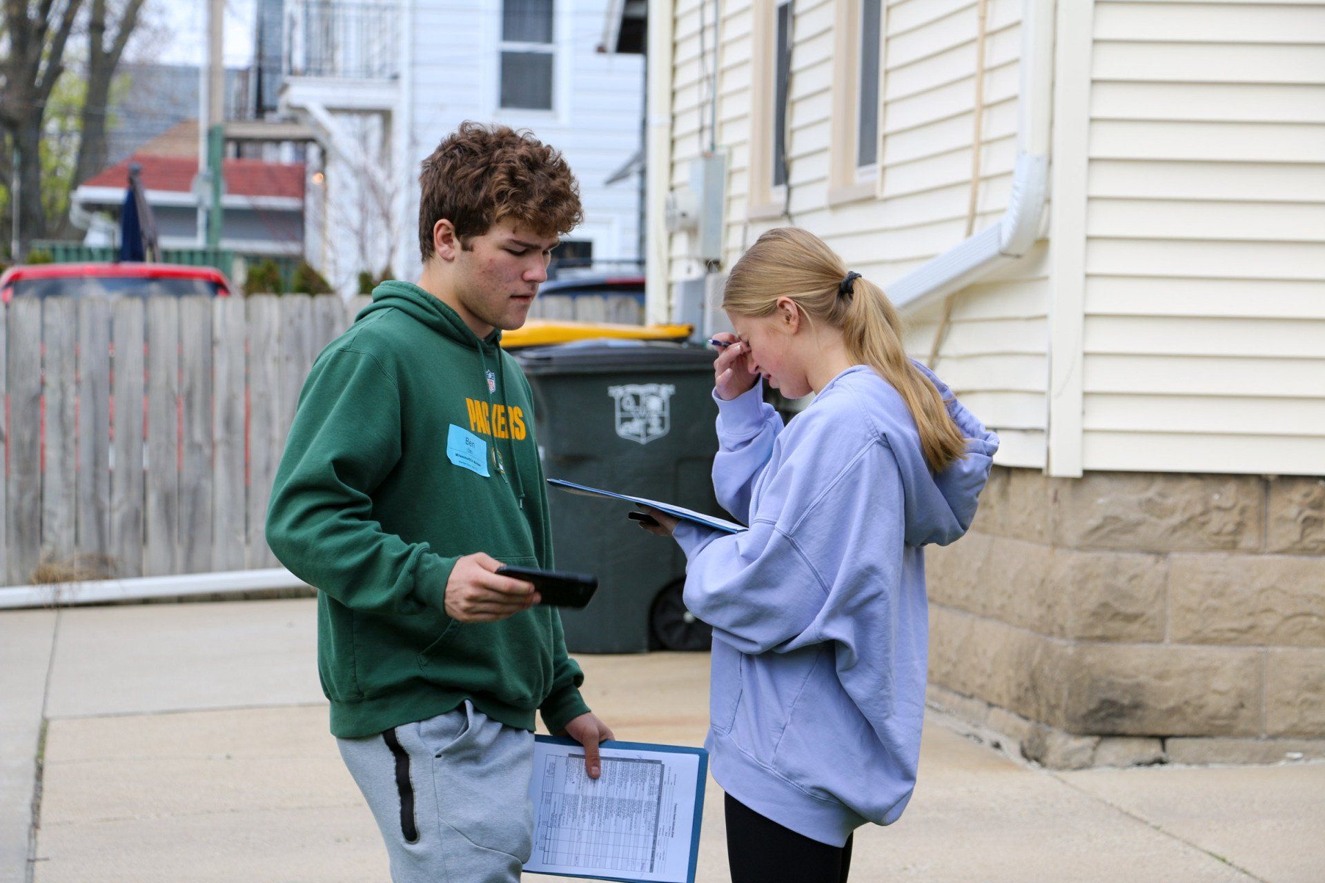A man and a woman are standing next to each other on a sidewalk.