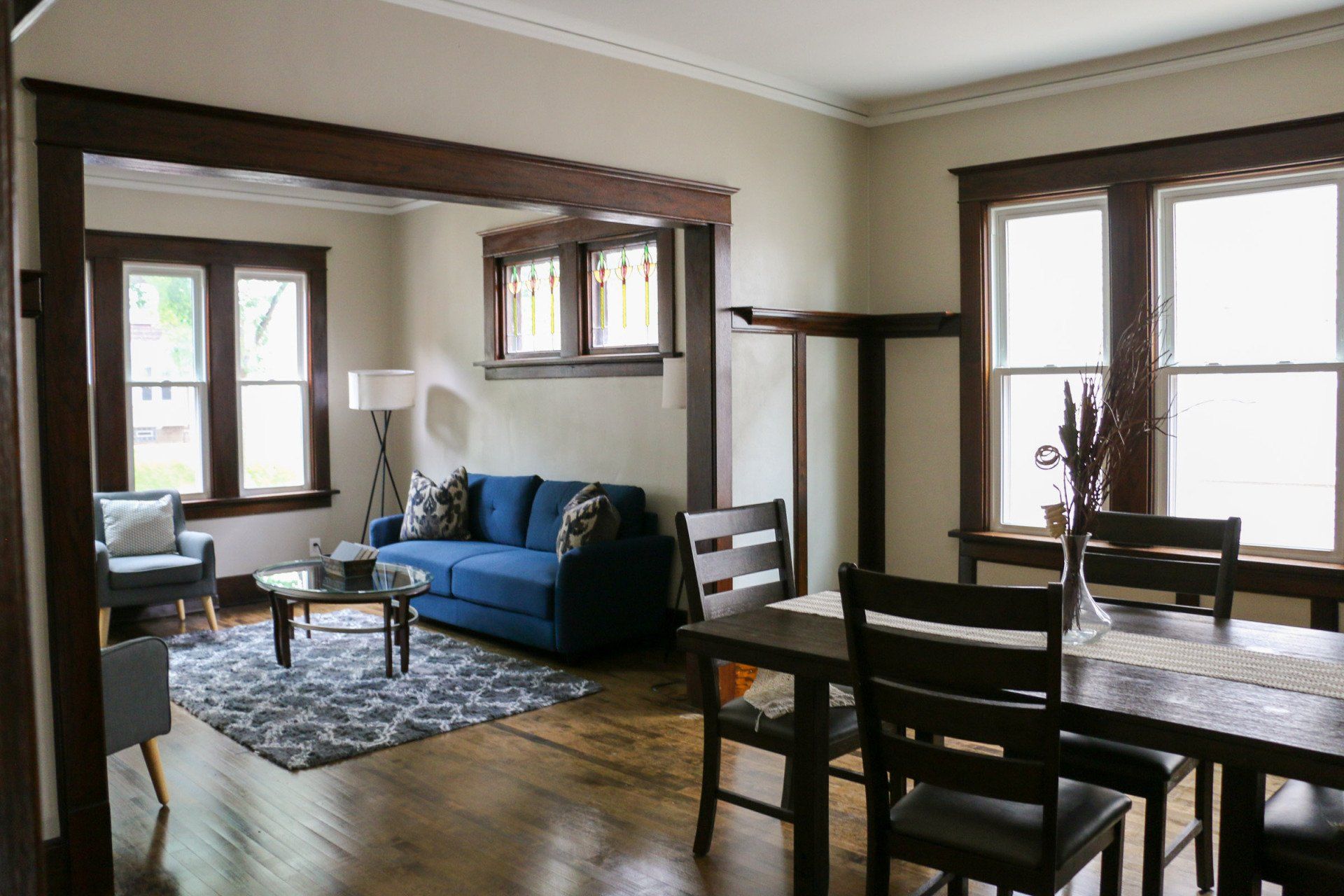 A living room with a blue couch and a dining table