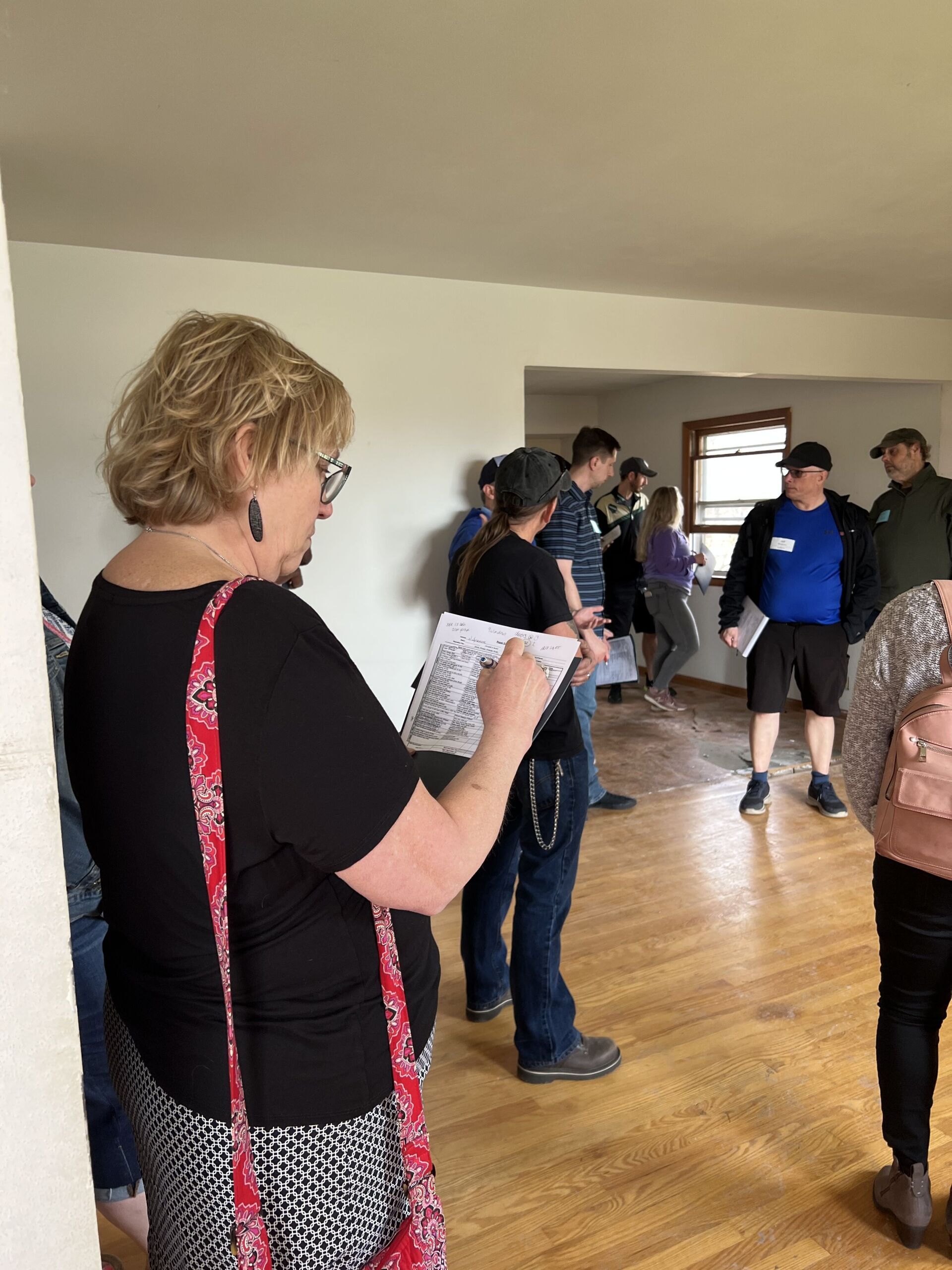 A woman is standing in a room with a group of people.
