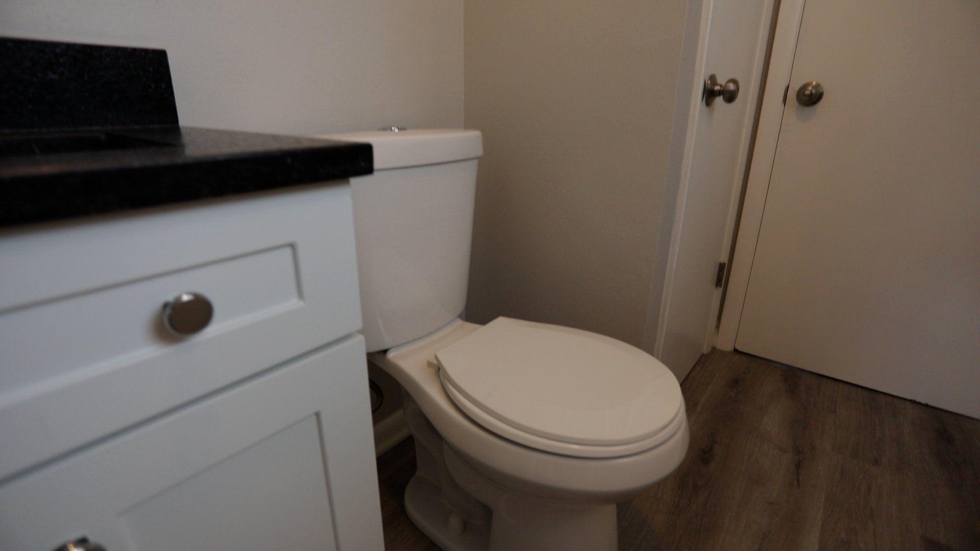 A bathroom with a toilet , sink , and door.
