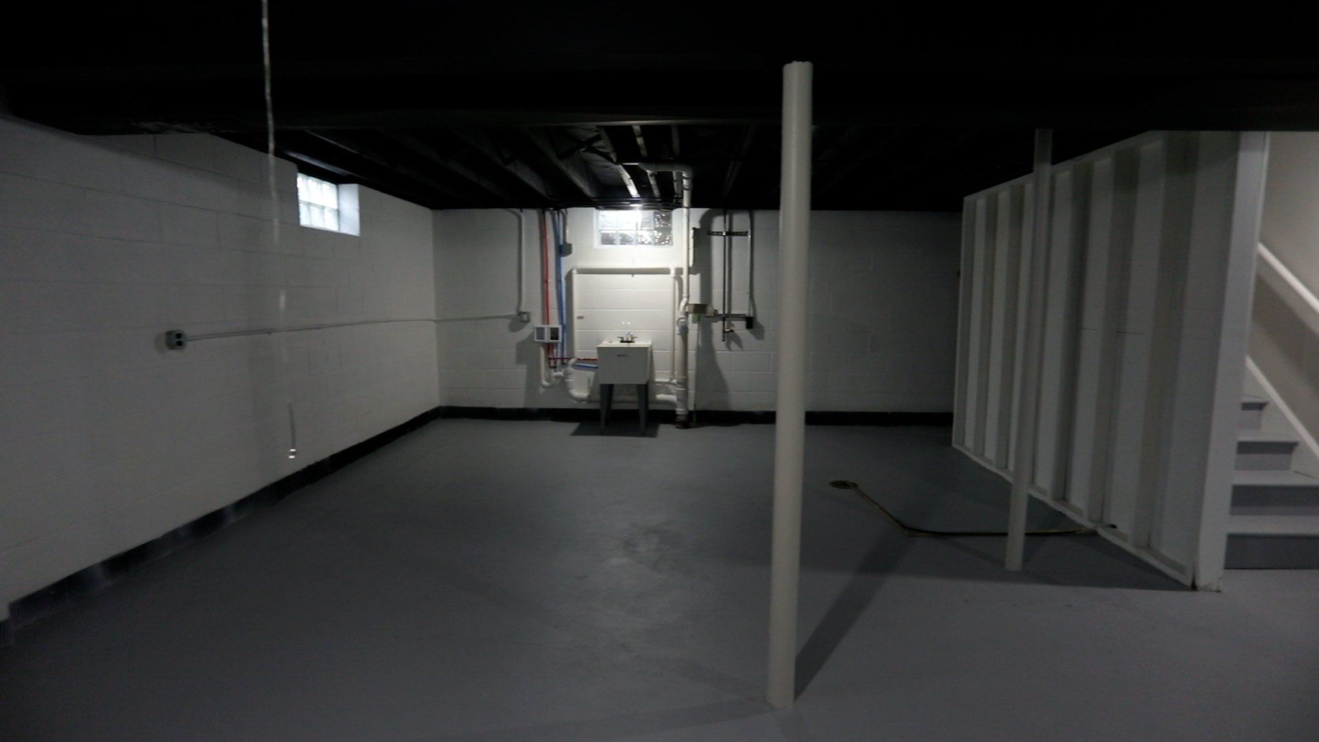 An empty basement with a toilet and stairs