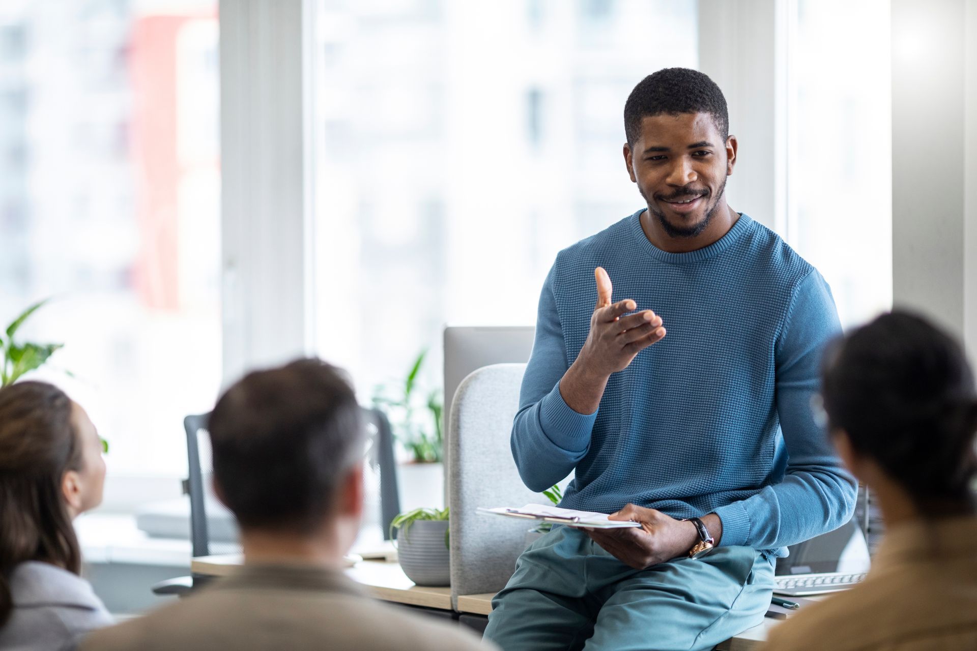 A man is sitting at a table talking to a group of people.