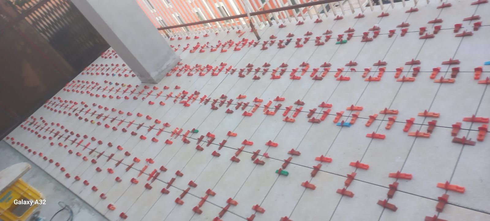 Scena su un tetto con file di decorazioni a forma di palloncino rosse e bianche su un pavimento piastrellato vicino a una ringhiera