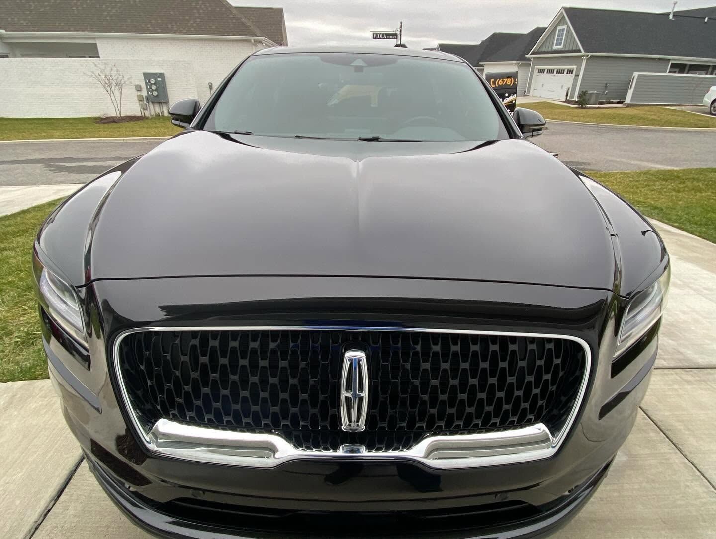 Front view of a black Lincoln SUV parked in a residential driveway