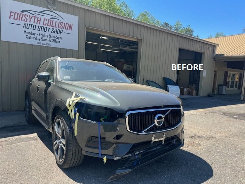 Black Volvo SUV at a collision repair shop with front-end damage, labeled “BEFORE”