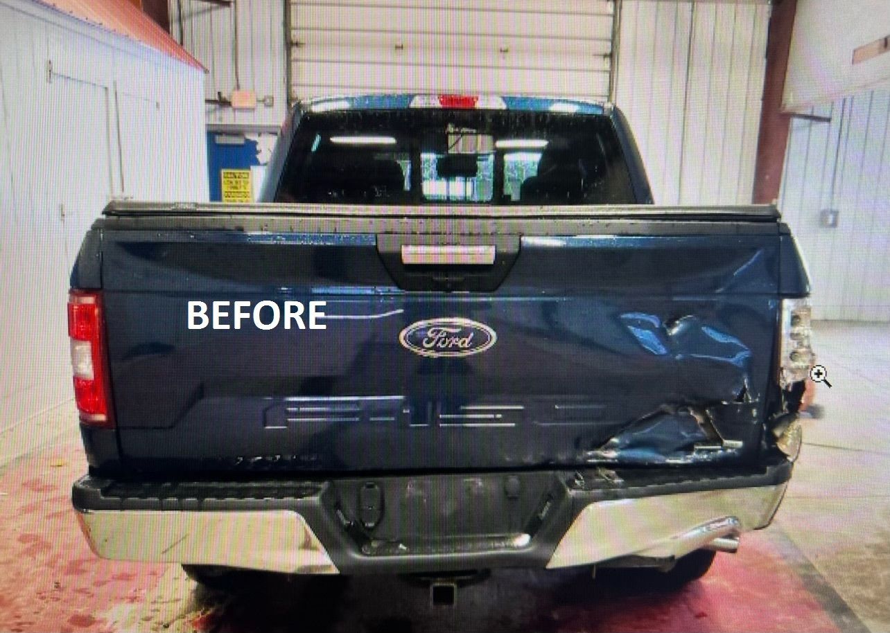 Damaged dark blue pickup truck tailgate in a garage, marked “BEFORE.”
