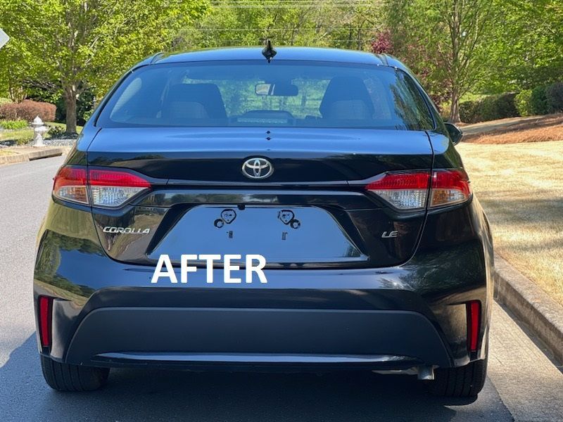 Rear view of a black Toyota sedan with “AFTER” text on the trunk, parked on a tree-lined street.