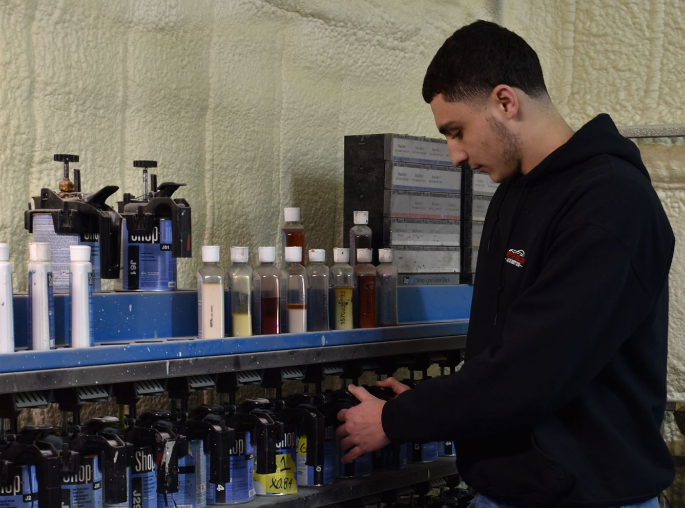 Man stocking shelves with bottles in a store aisle
