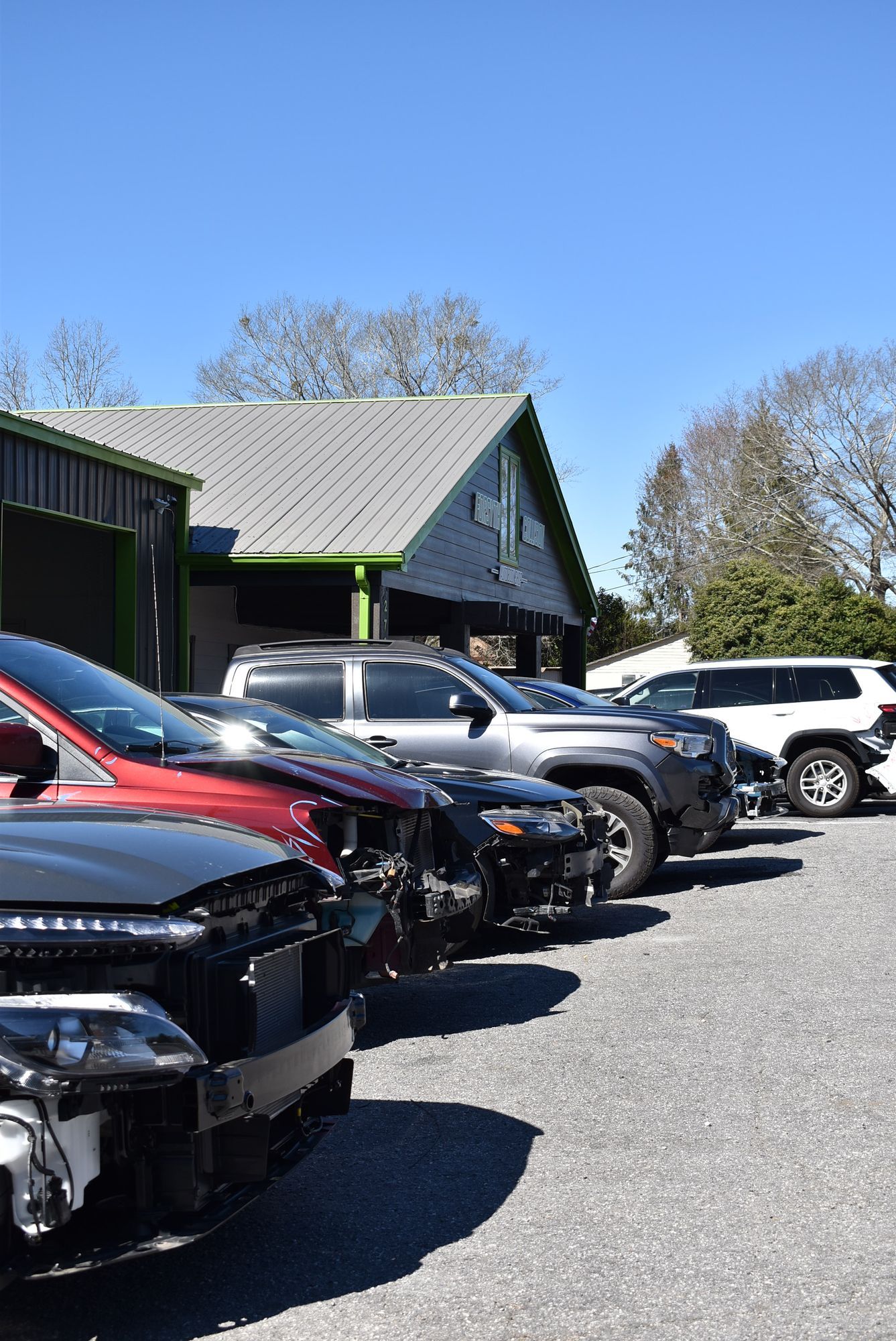 Parked cars lined up beside a building under a clear blue sky.