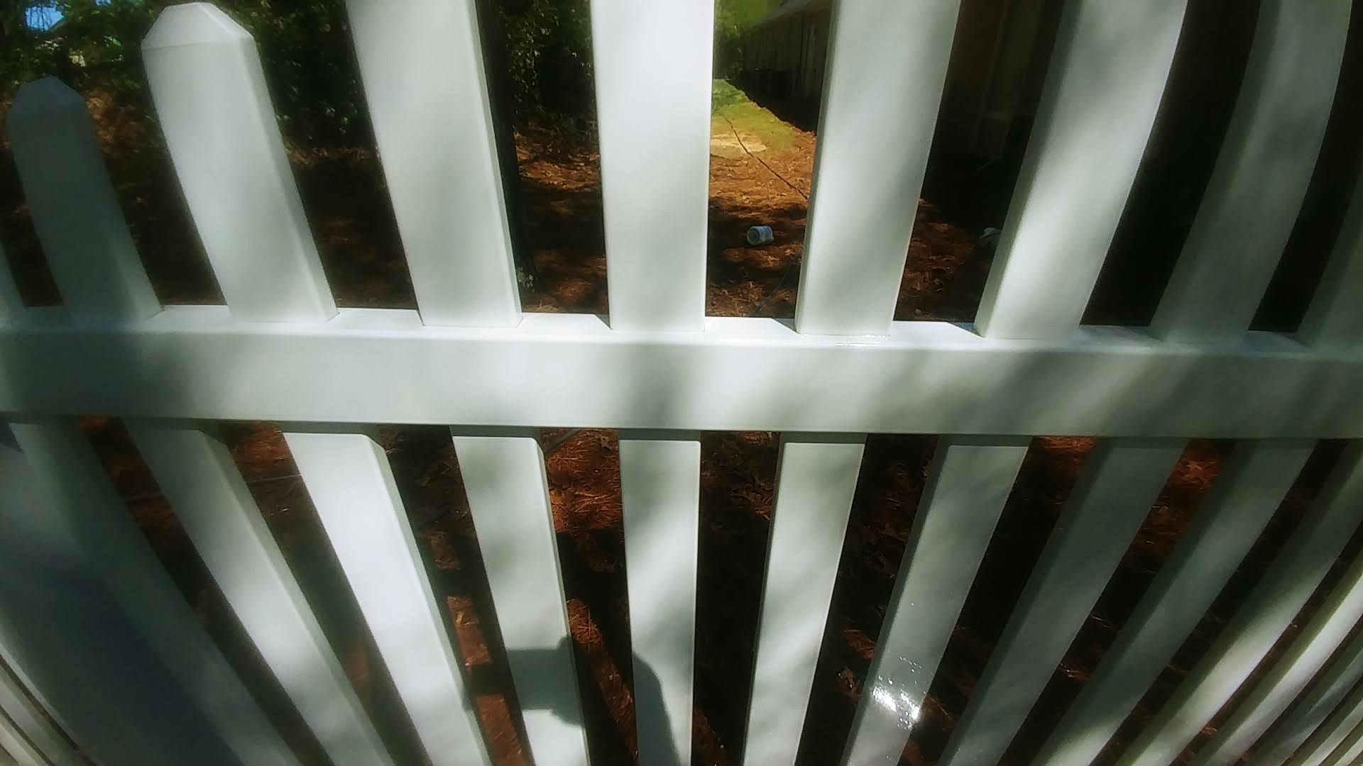 A white picket fence with a tree in the background