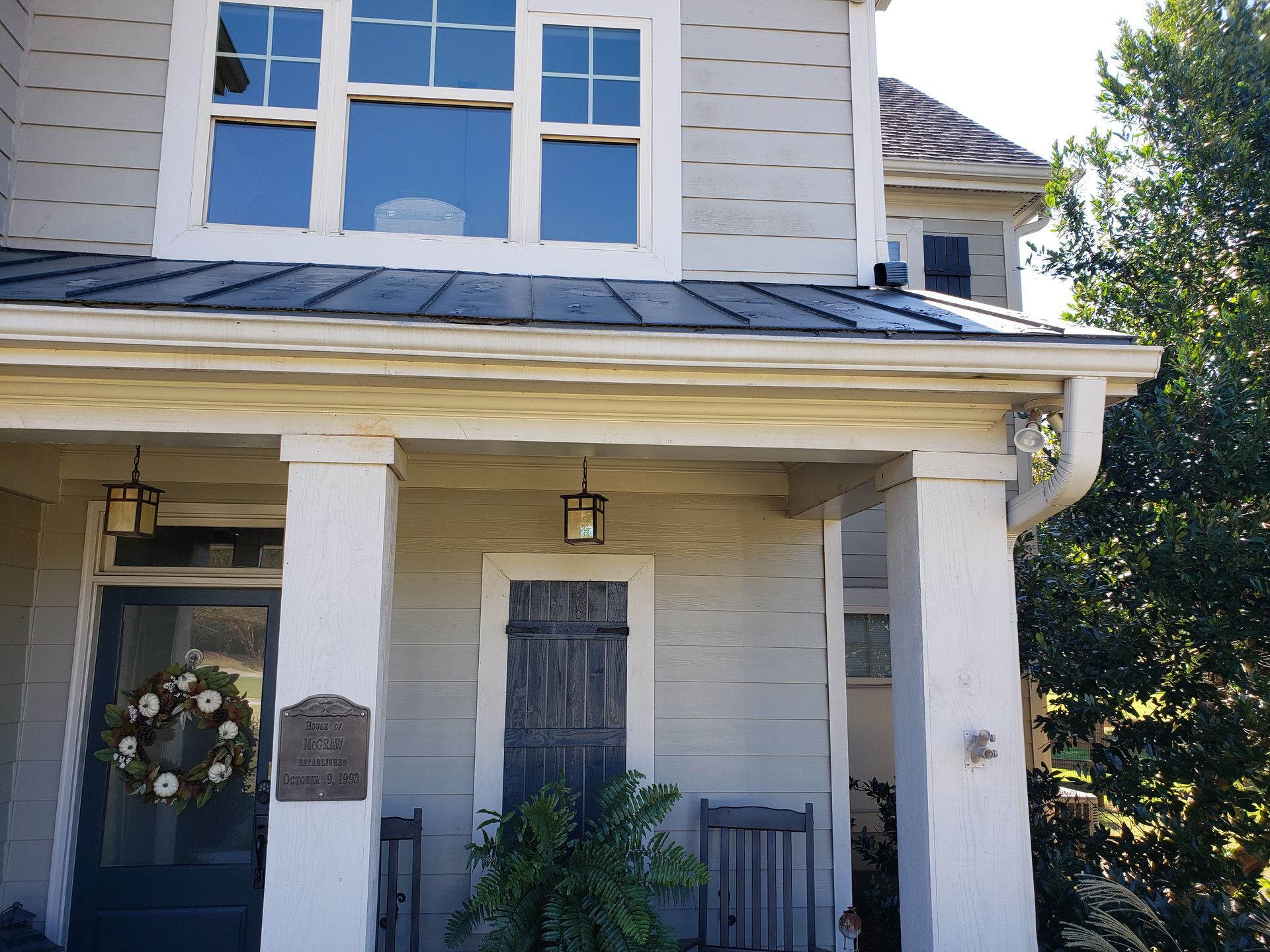 A white house with a porch and a black door