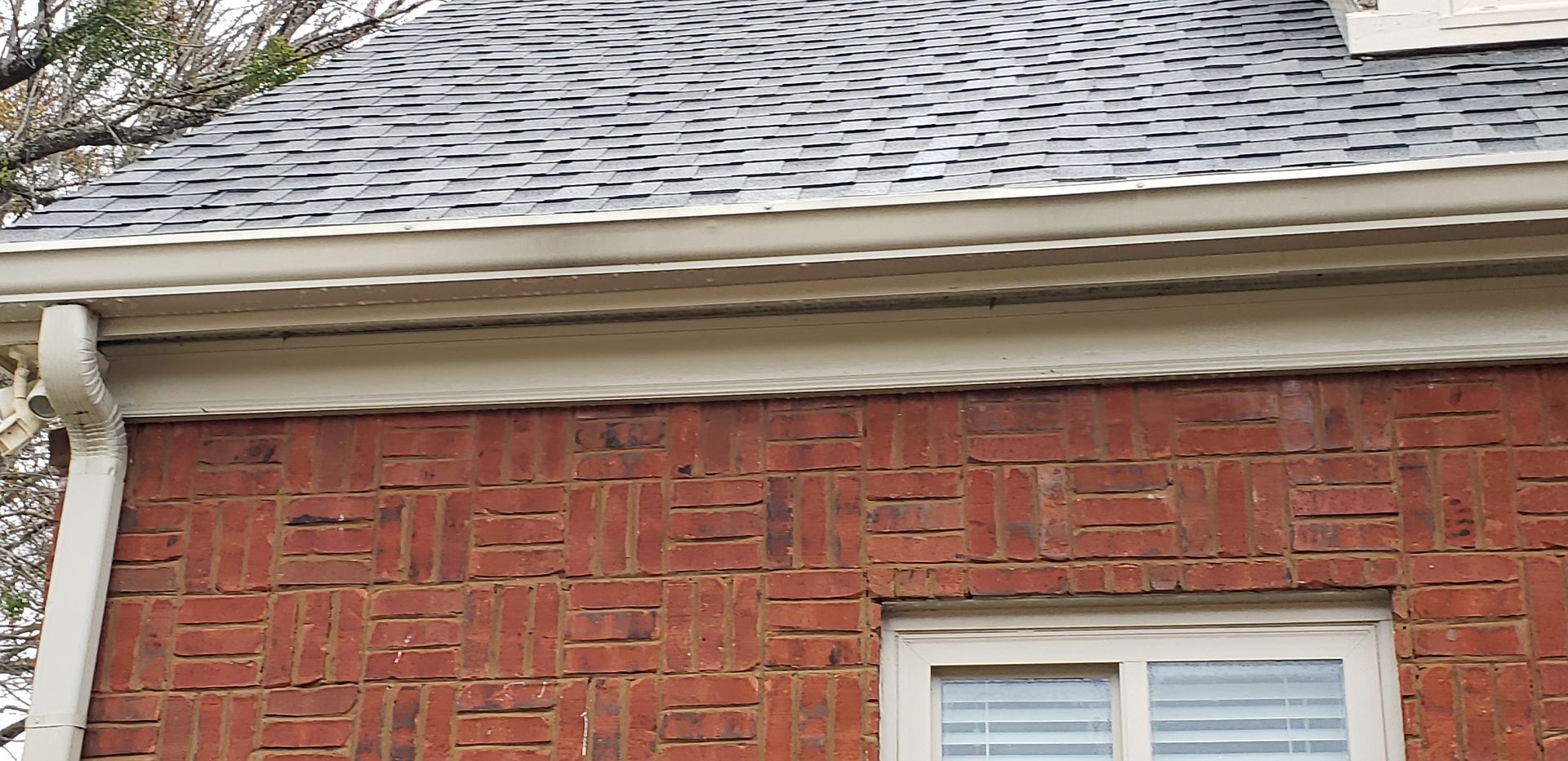 A brick building with a window and a roof.