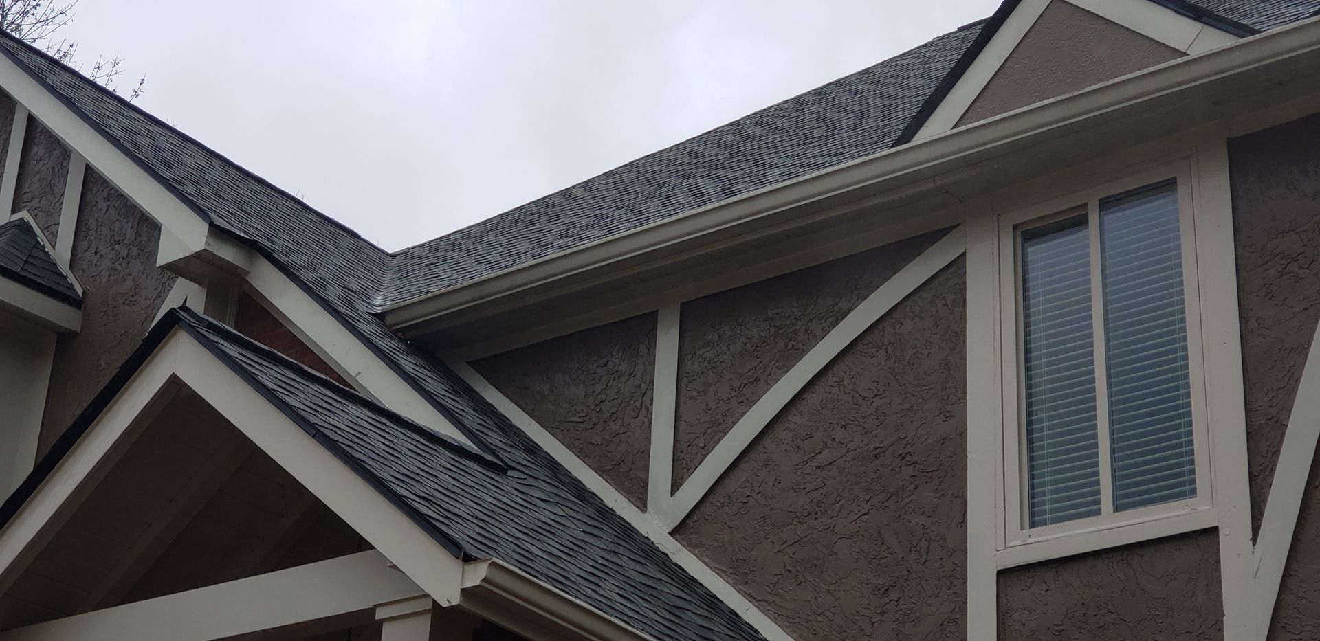A close up of a house with a roof and a window