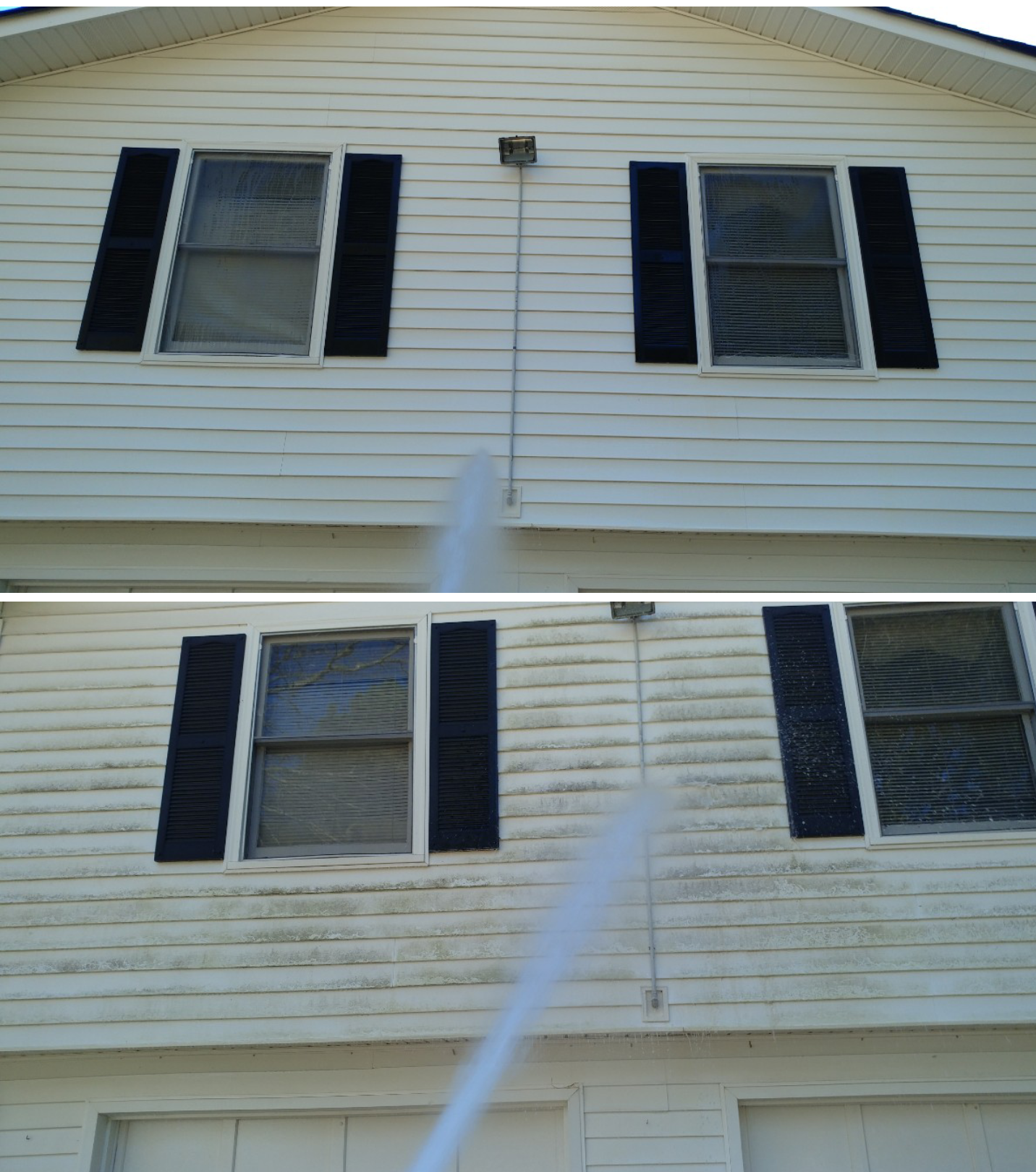 A man is using a high pressure washer to clean the side of a house.