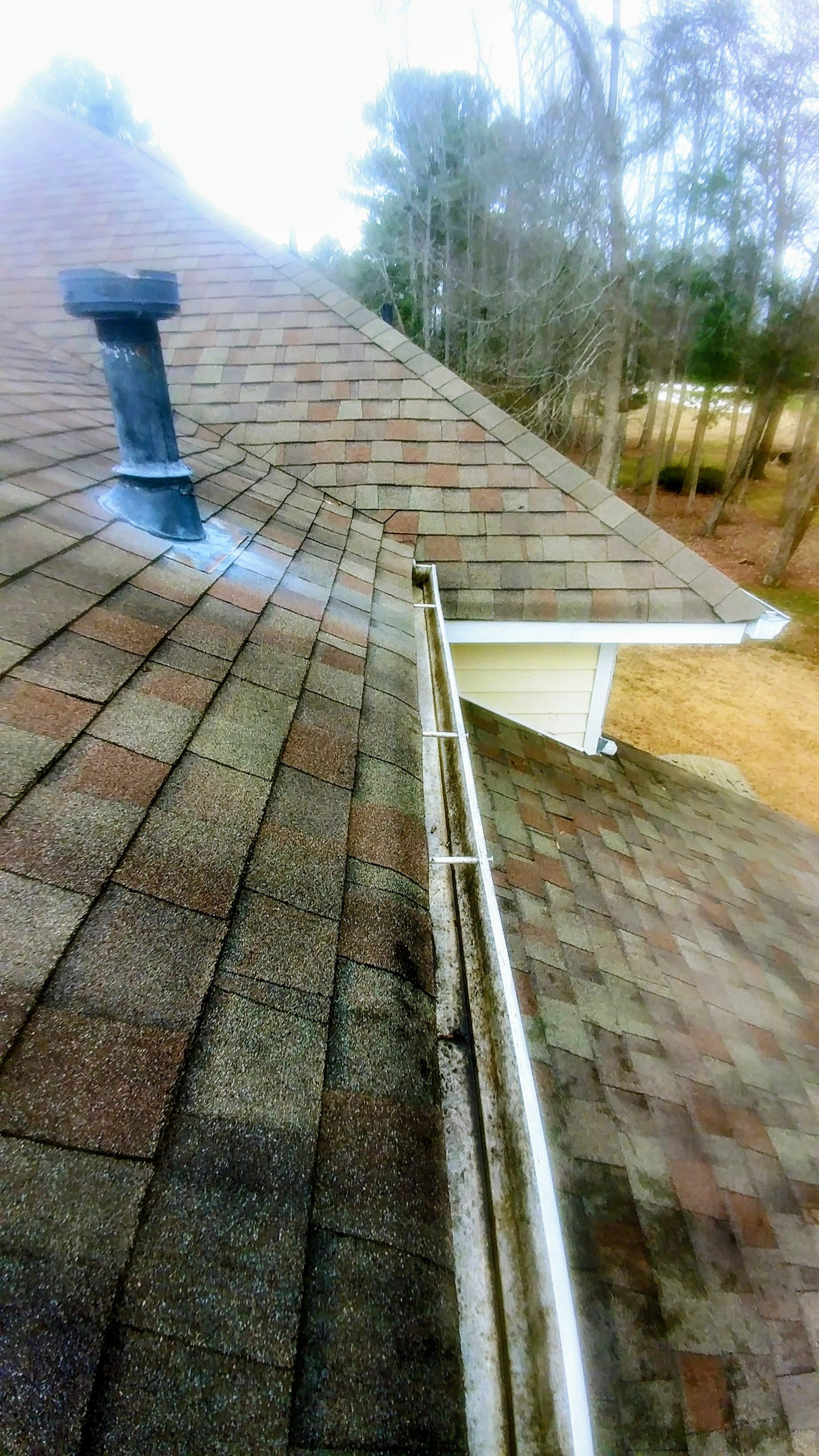 A roof with a gutter and a chimney on it.