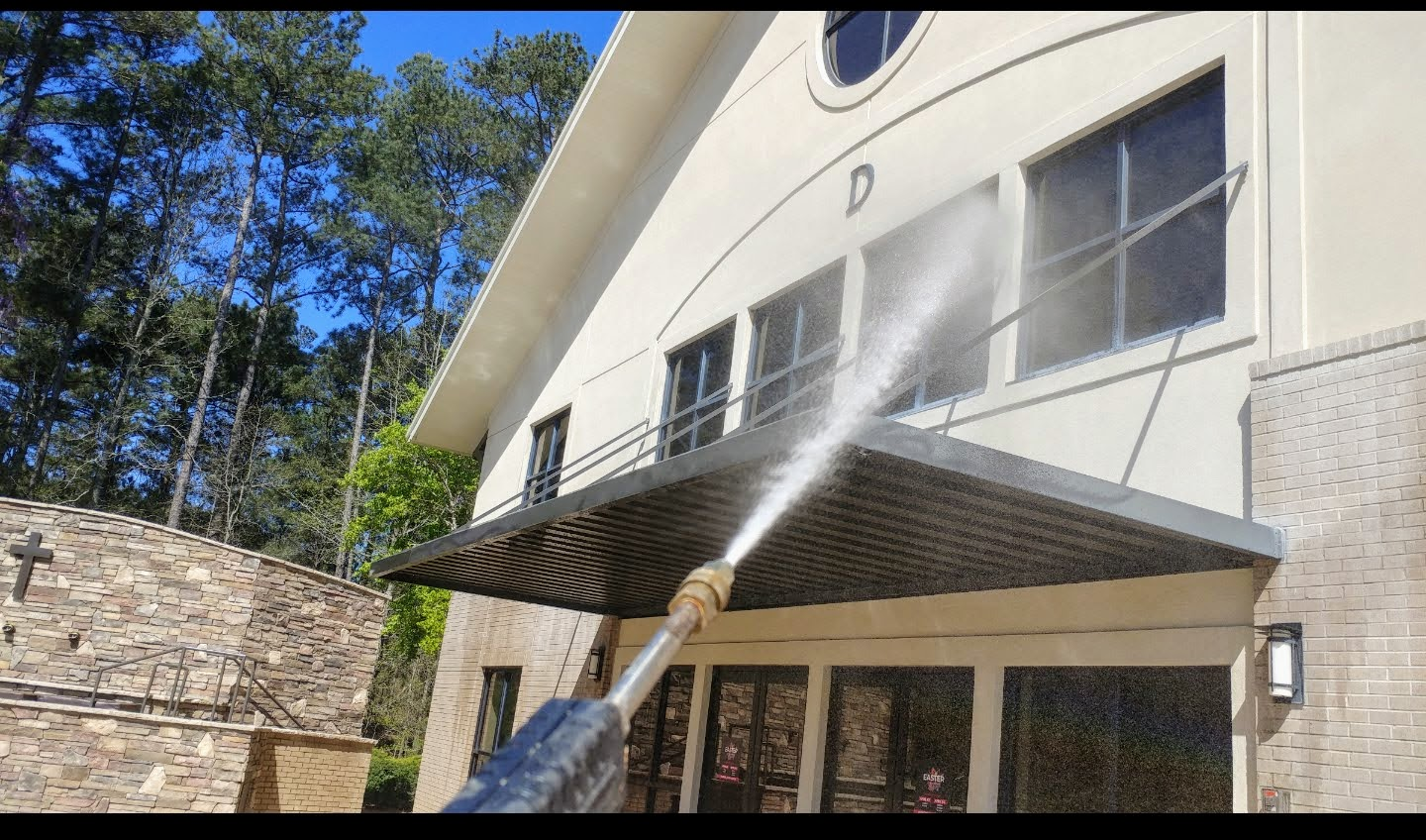 A house is being cleaned with a high pressure washer.