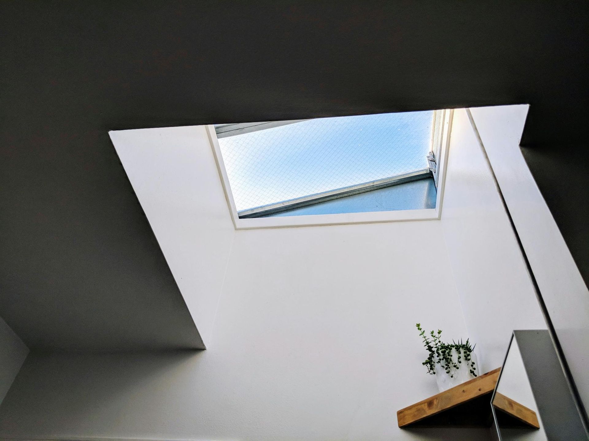 Looking up at the sky through a skylight in a room.
