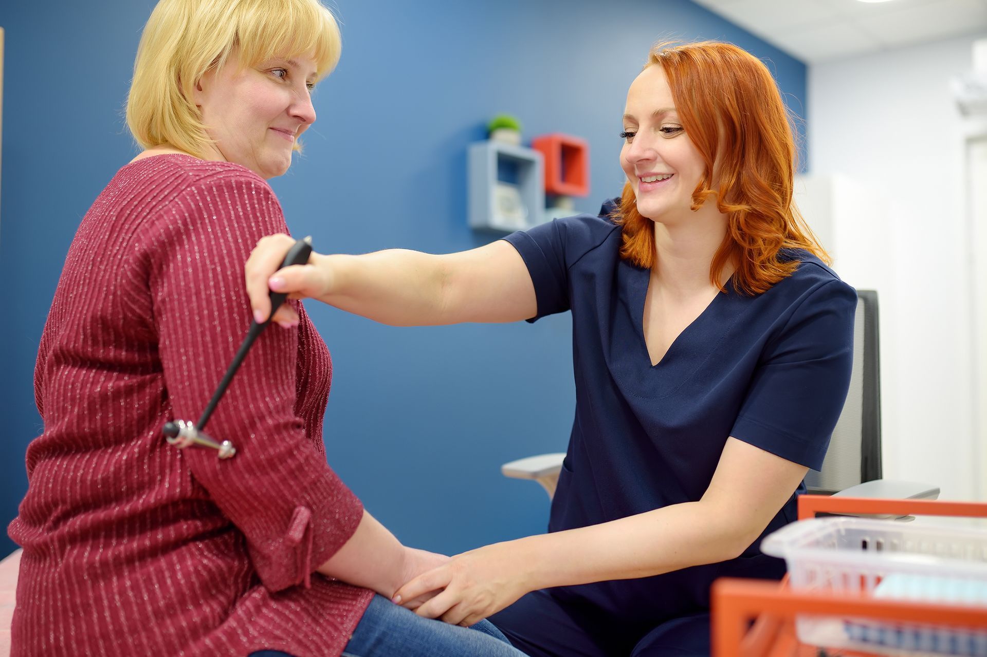 Neurologist performing a reflex exam as part of MS treatment and diagnosis Neurologist performing a reflex exam as part of MS treatment and diagnosis
