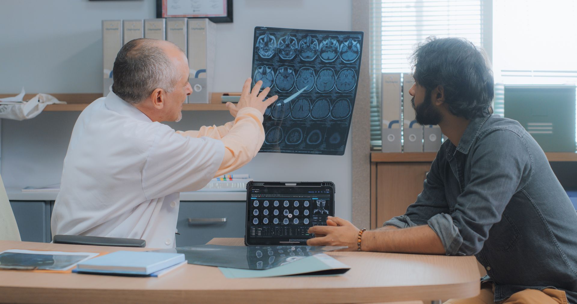 Doctor reviewing brain scan images with a patient during a medical consultation.
