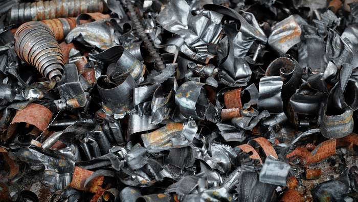 A pile of scrap metal is sitting on the ground. A pile of scrap metal is sitting on the ground.