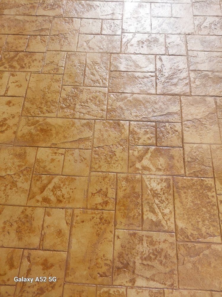 Tan textured beige stone tile floor with a glossy finish and rectangular grout pattern