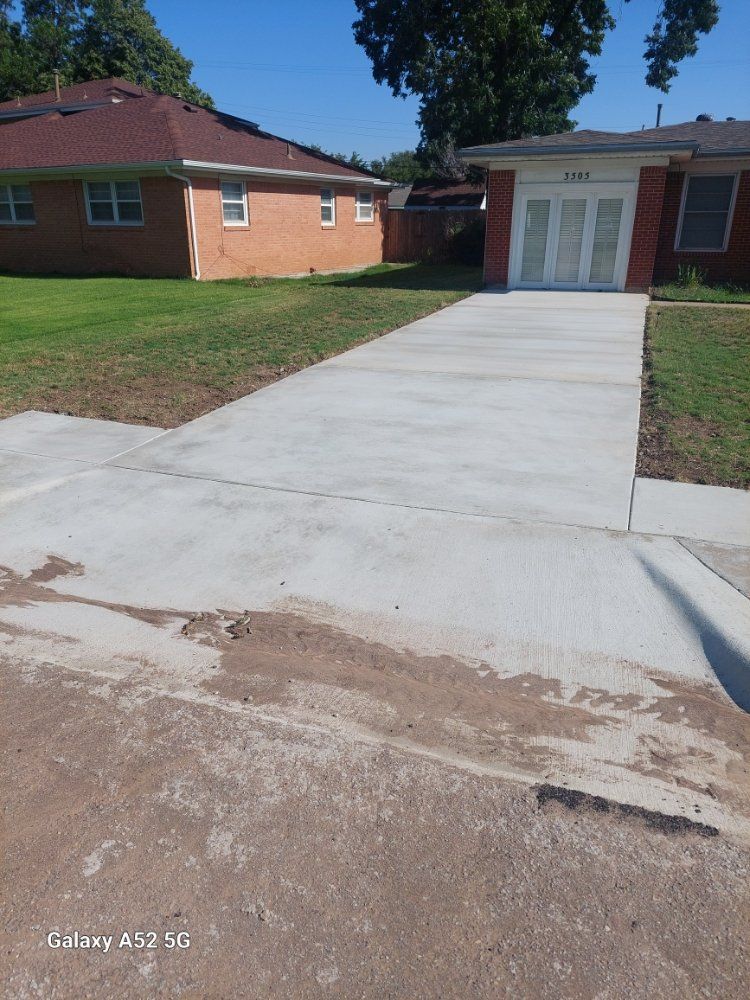 Concrete driveway leading to a brick building entrance on a sunny day