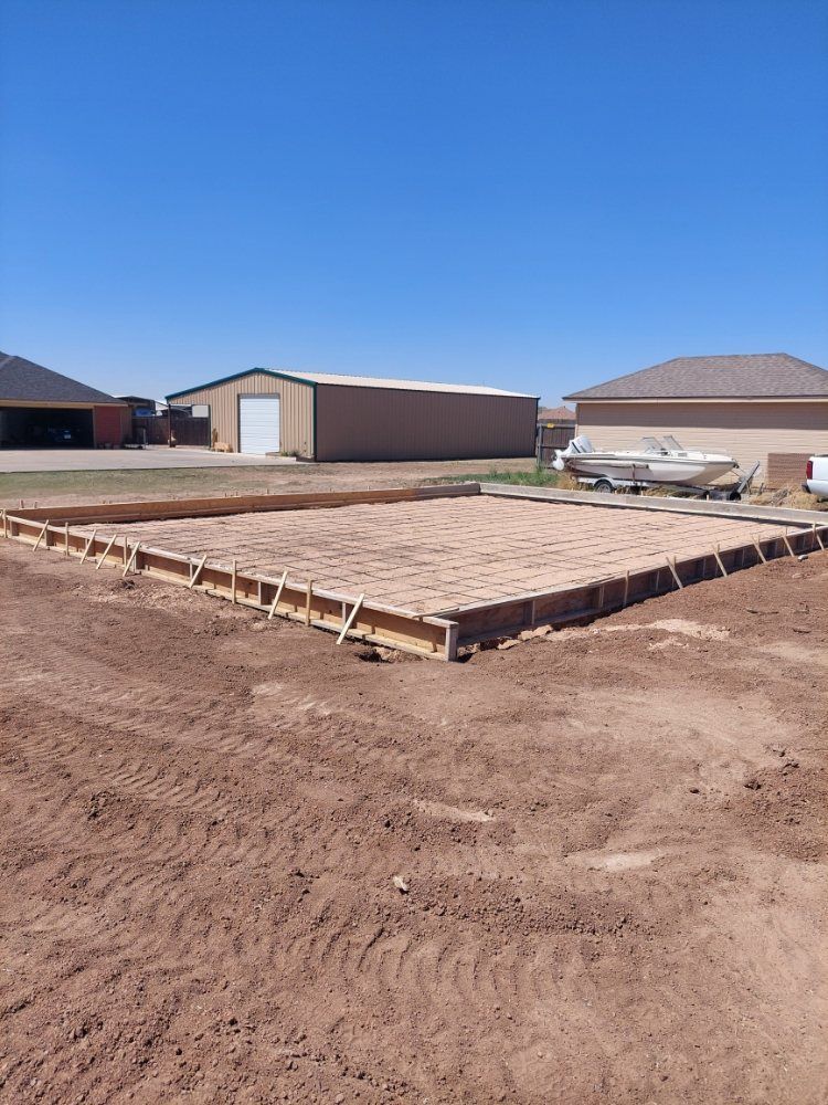 Foundation slab framed at a new house construction site under a clear blue sky