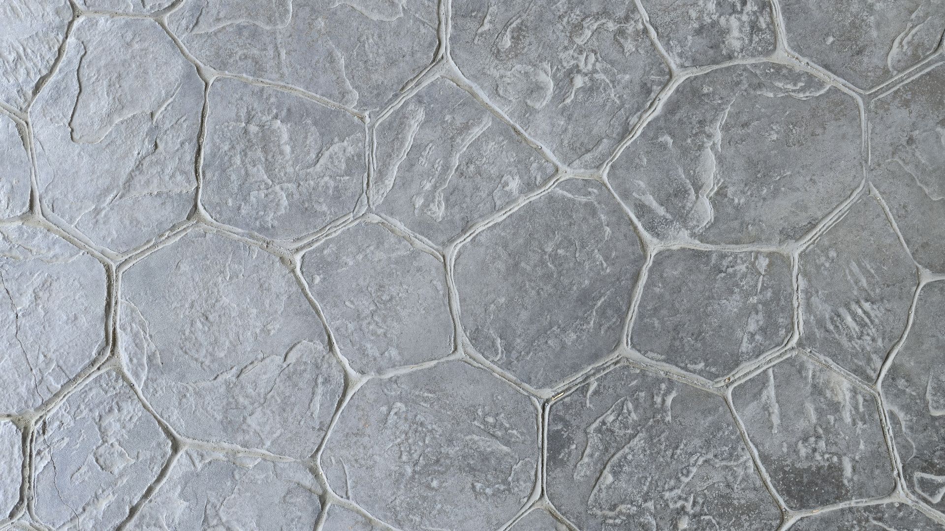 Gray stone pavement with irregular hexagonal tiles and textured grout lines