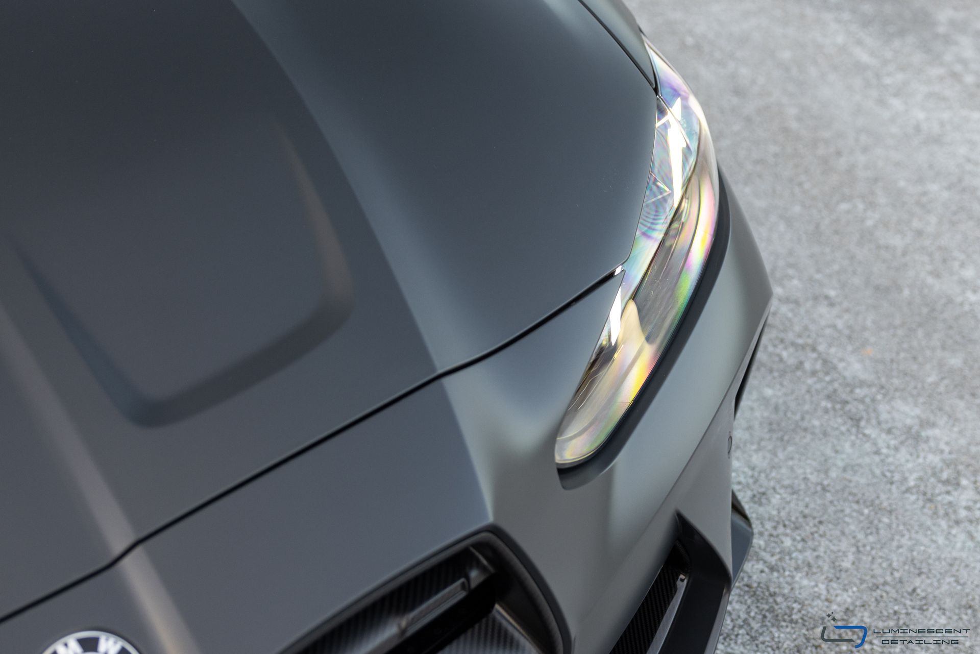 Close-up of a matte black sports car front corner on pavement