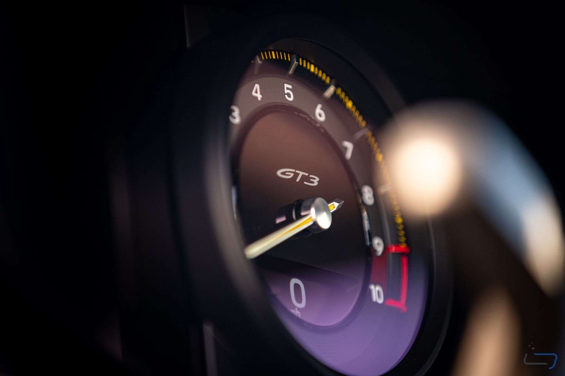 Close-up of a Porsche GT3 tachometer with redline markings and illuminated gauge cluster