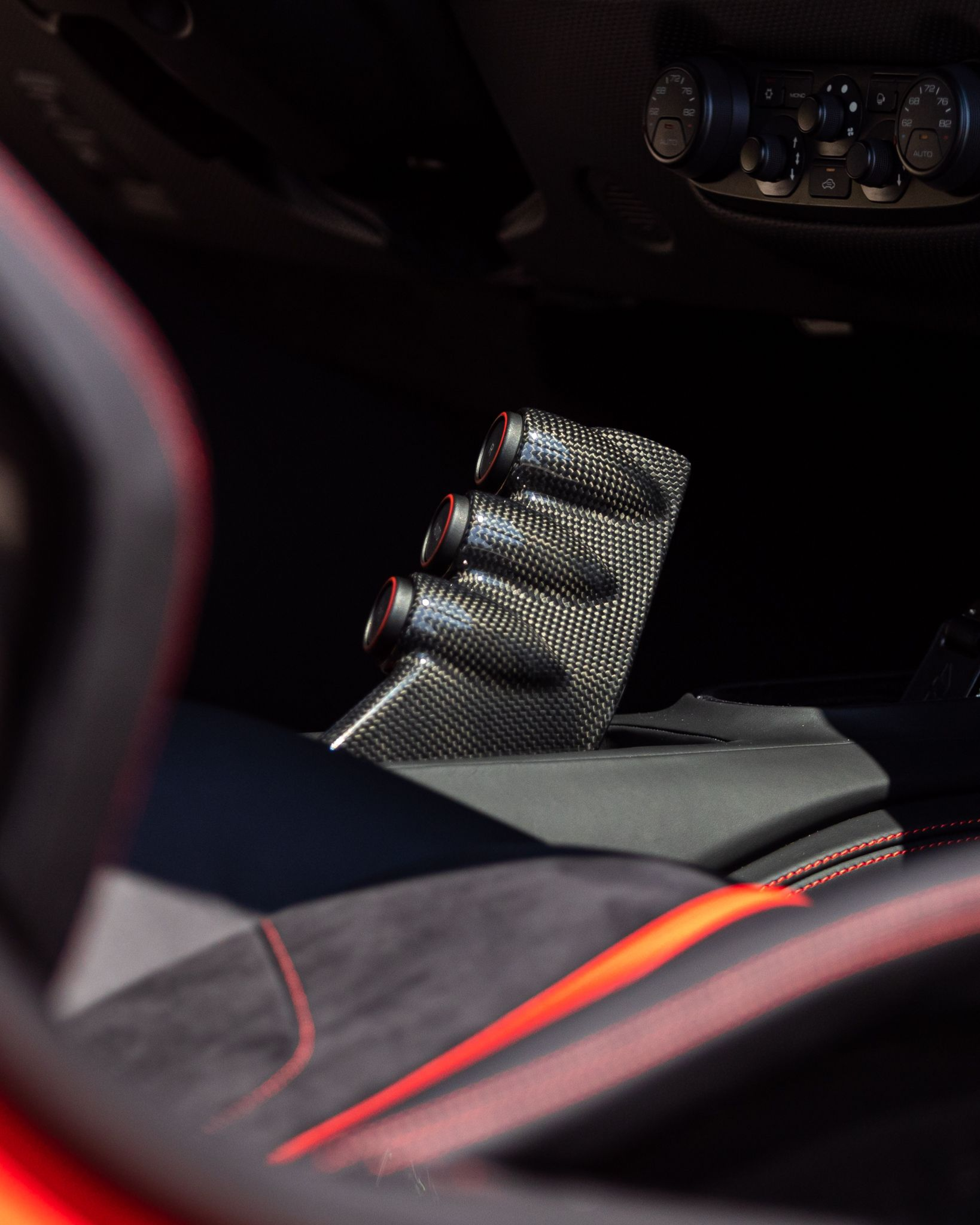 Close-up of a car interior with a carbon-fiber phone mount near the center console.