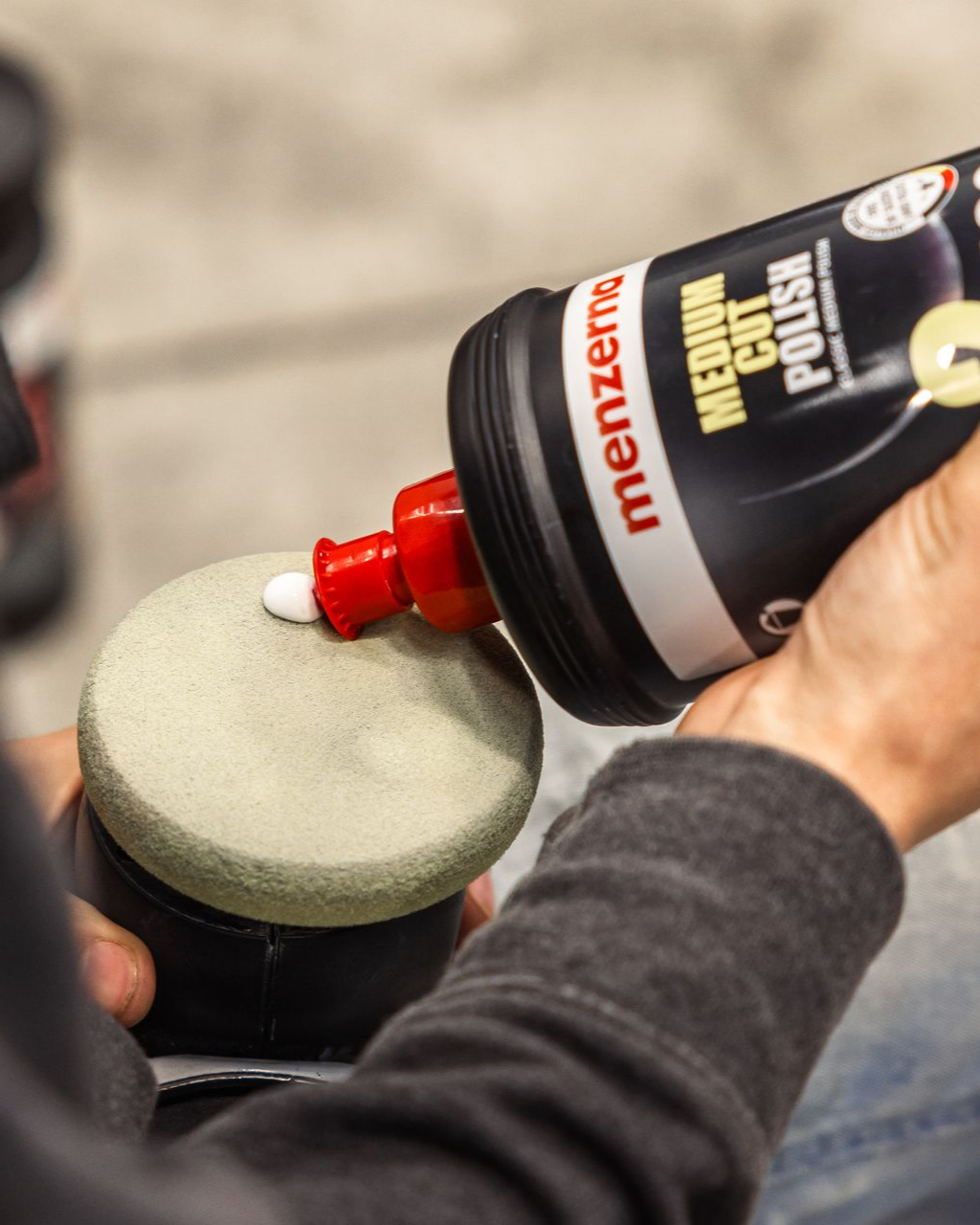 Applying red compound to a foam buffing pad with a polishing bottle