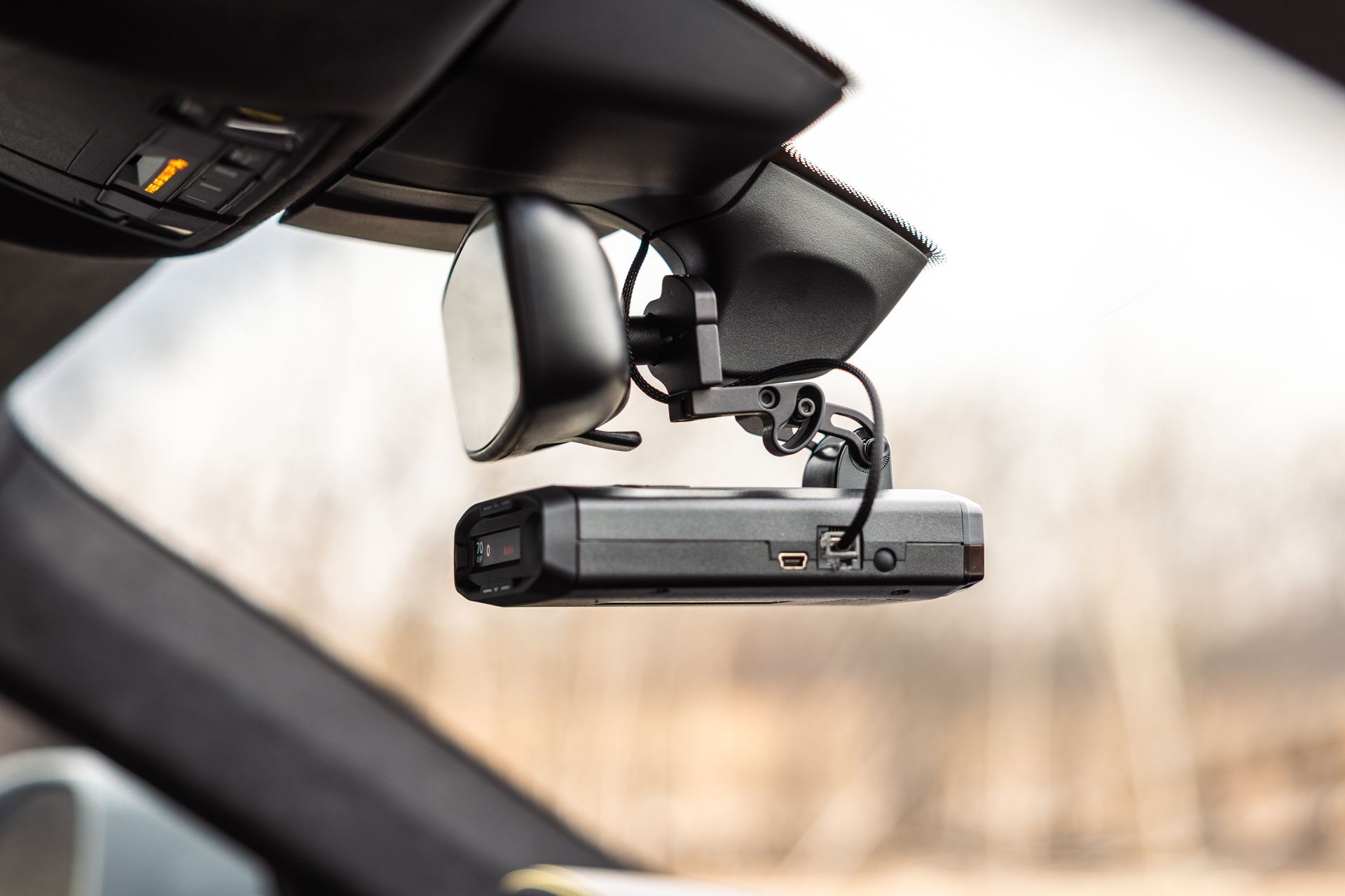 Dashcam mounted on a car windshield, facing forward on a sunny day