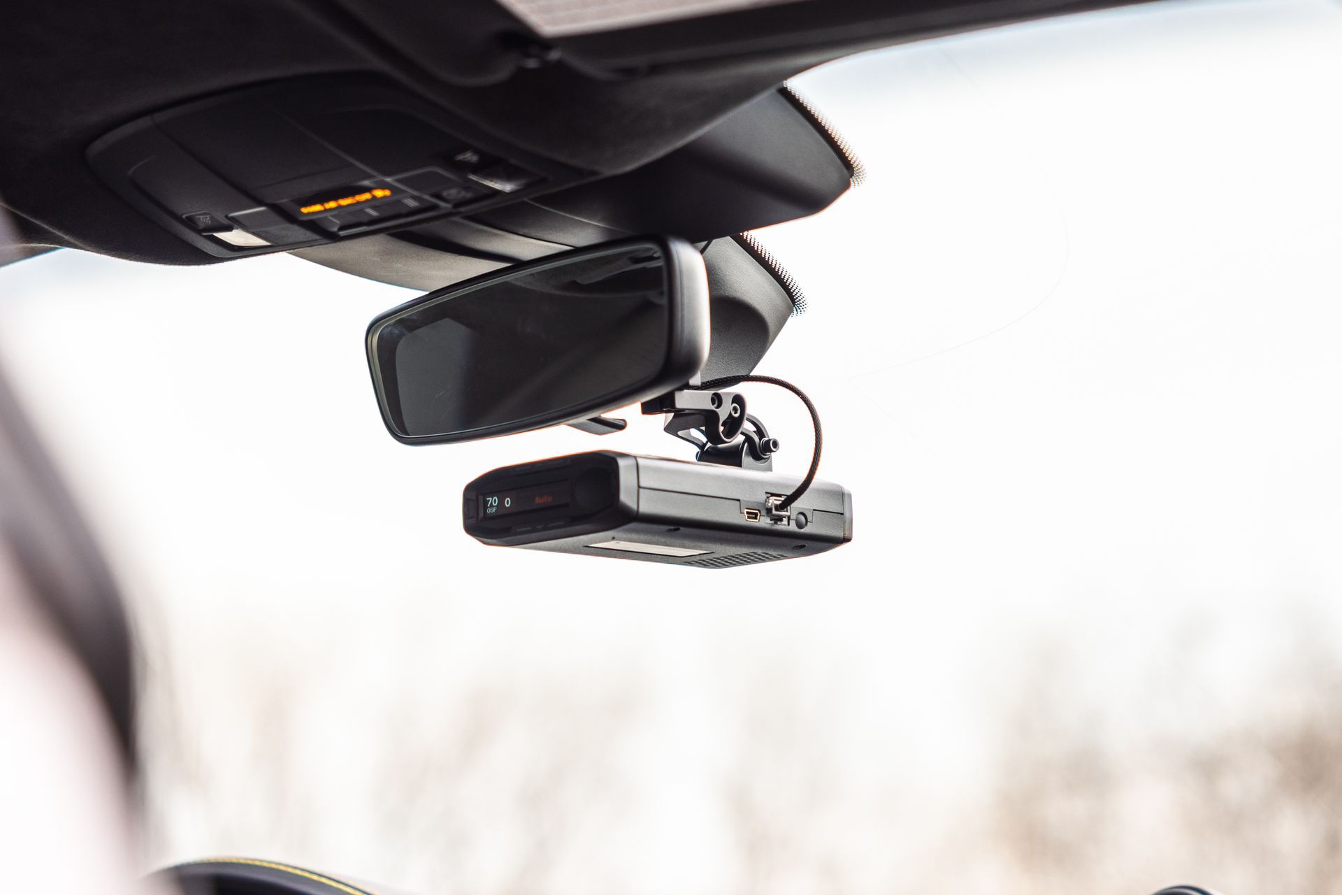 Dashboard-mounted dash camera attached near a car’s rearview mirror