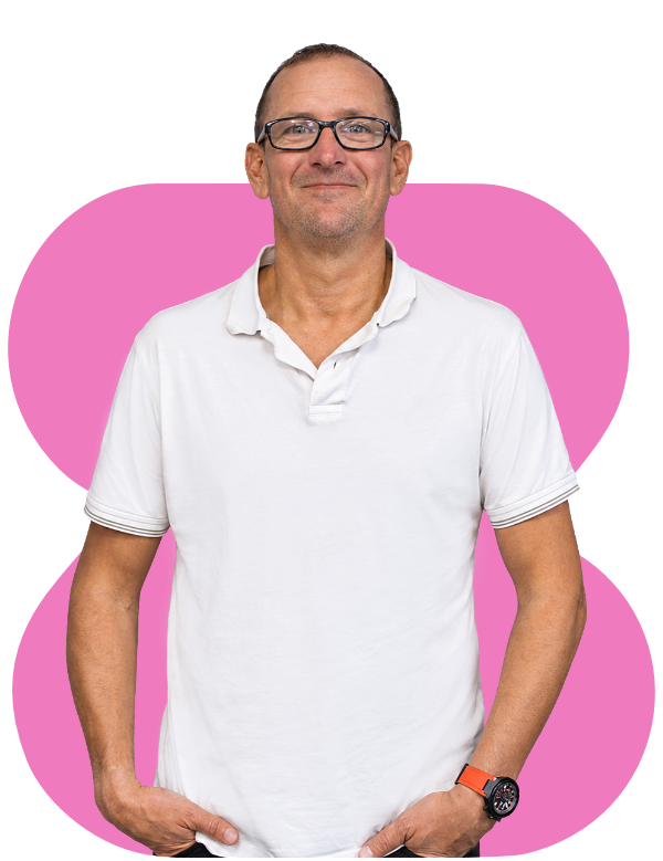 Man in white polo shirt and glasses standing in front of a pink abstract background
