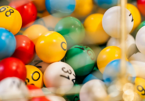 Colorful numbered lottery balls clustered together in a transparent container