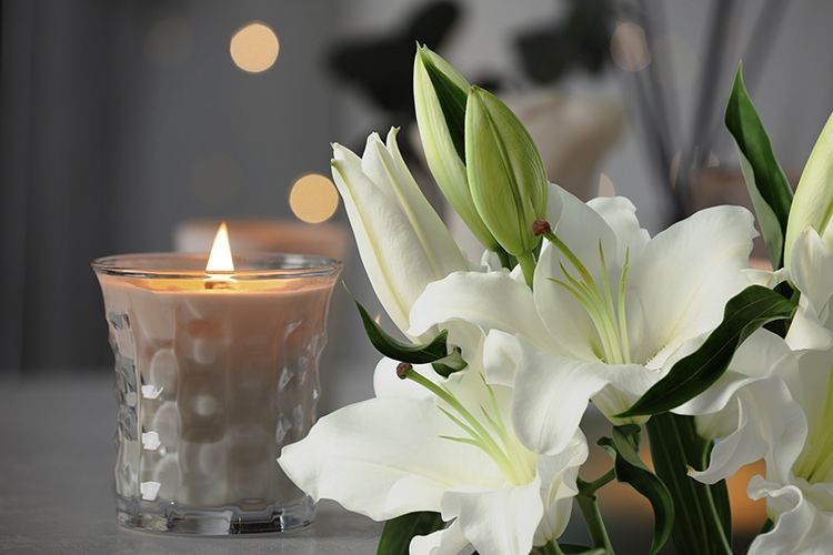 There is a candle and flowers in the background.
