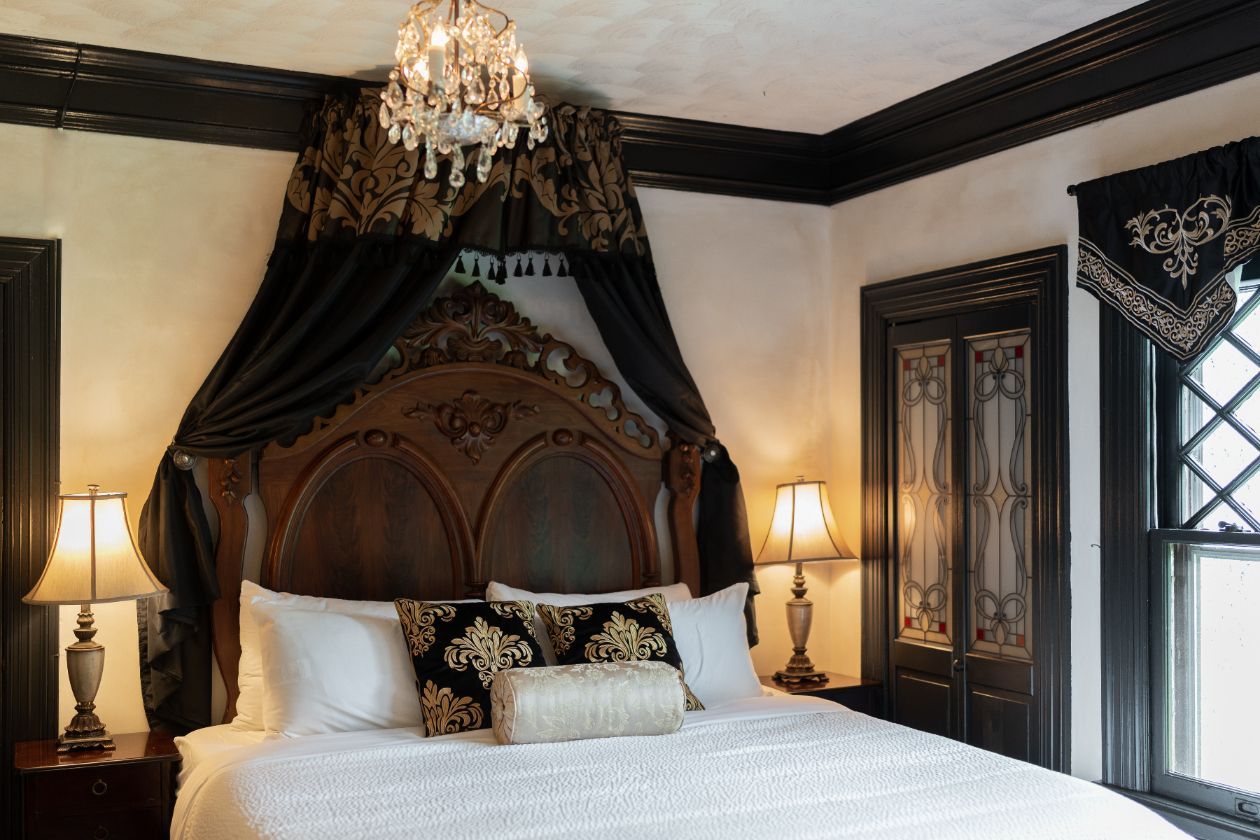 A bedroom at a New England Country Inn with a king-size Lincoln bed and a chandelier